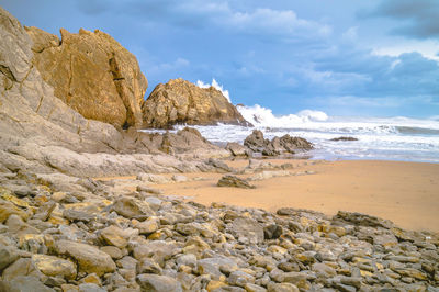 Rocks on beach against sky