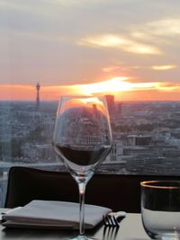 Close-up of beer glass on table against sky during sunset