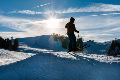 Man and woman on snowcapped mountains against sky during winter