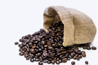 Coffee beans spilling on white background