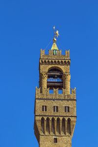 Low angle view of clock tower against blue sky