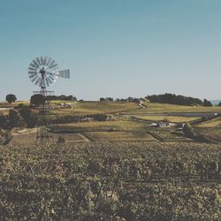 Traditional windmill on field against clear sky