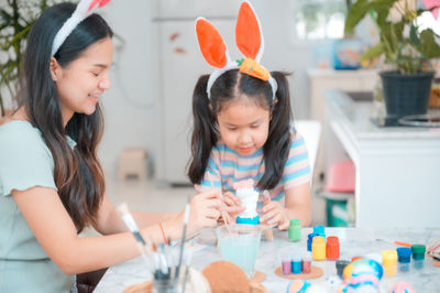 Girl holding women while standing on shelf