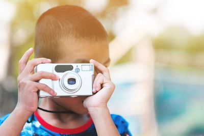 Close-up portrait of boy photographing