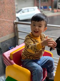 Portrait of smiling boy sitting outdoors