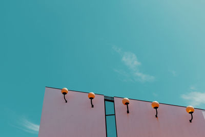 Low angle view of birds perching on blue sky