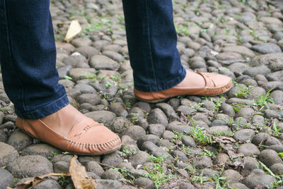 Low section of woman standing on stones