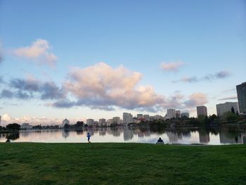 Scenic view of river by buildings against sky