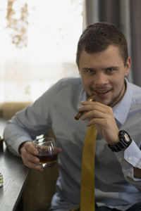 Portrait of young man sitting on table