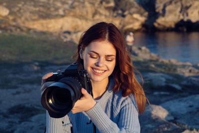 Portrait of smiling woman photographing water