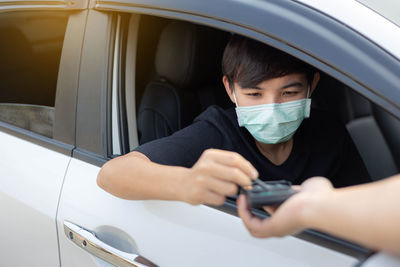 Portrait of man holding car