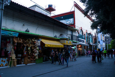 People on street market against buildings in city