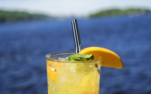 Close-up of drink in glass against water