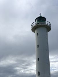 Lighthouse by sea against sky