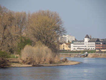 River by buildings against clear sky