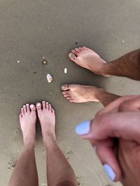 Low section of person standing on sand