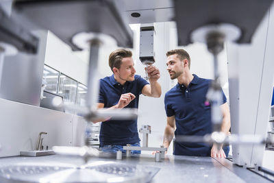 Two men at a machine in testing instrument room