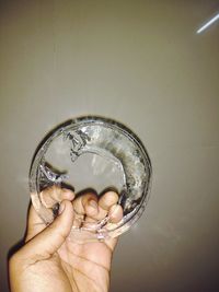 Human hand holding glass of water