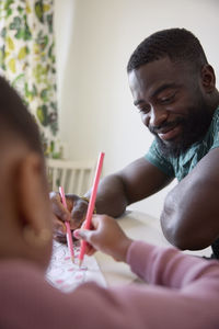 Father and daughter drawing together at home