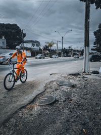 Man riding bicycle on road in winter