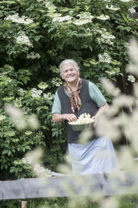 Portrait of a smiling young woman holding plants