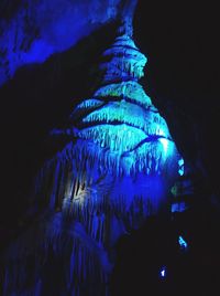 Low angle view of illuminated lighting equipment in cave