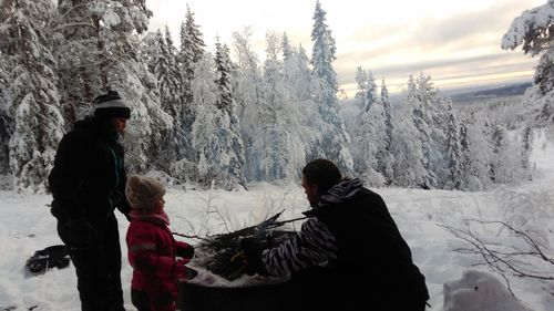 Family burning campfire on snow