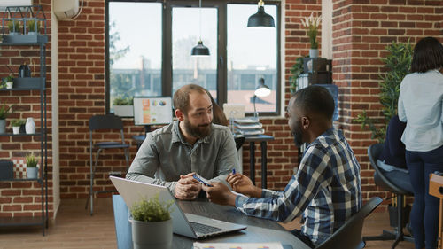 Portrait of man using laptop while sitting on table