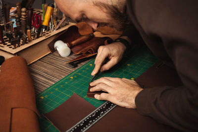 Leatherworker rounds. tanner works with leather, small business, production.