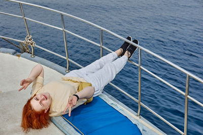 Woman lying on boat in sea