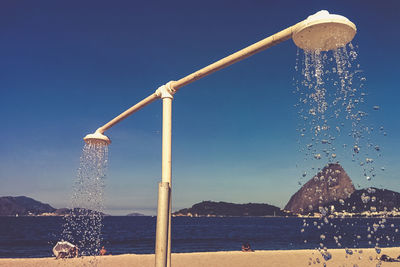 Showers at beach against clear sky