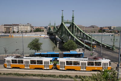 Train on bridge against sky in city