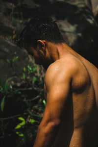 Shirtless wet muscular man standing outdoors