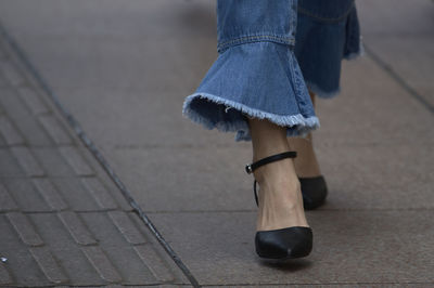 Low section of woman standing on footpath