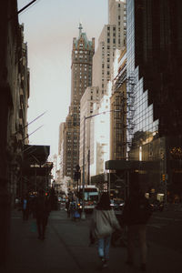 People walking on street amidst buildings in city