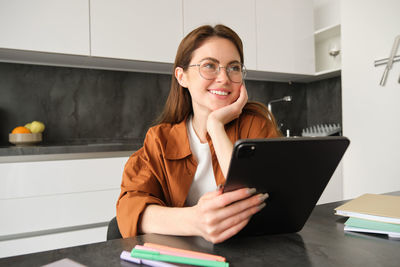 Portrait of young woman using laptop at home