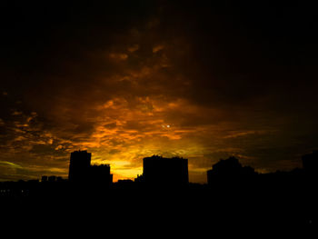 Silhouette city against sky during sunset