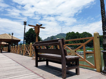 Empty chairs and table against sky