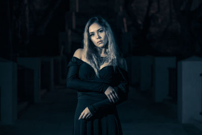 Portrait of beautiful woman standing outdoors at night