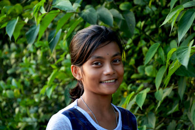 Portrait of smiling girl against plants