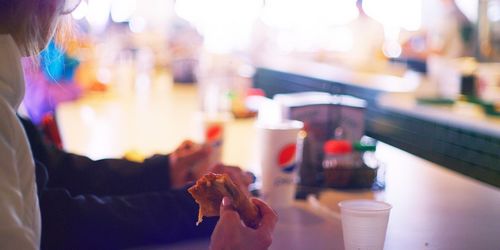 Close-up of hand holding drink at table