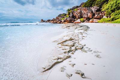 Scenic view of rocks on beach against sky