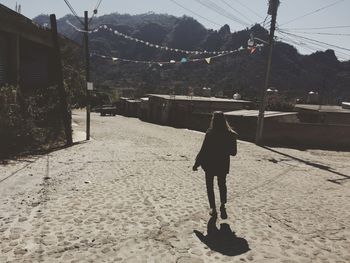 Rear view of woman walking on snow covered landscape