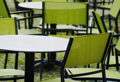 Empty chairs and tables in cafe outdoors