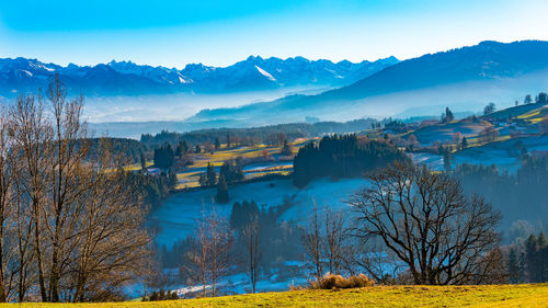 Scenic view of landscape and mountains against blue sky