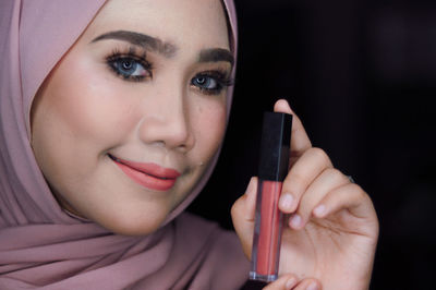 Close-up portrait of young woman holding cigarette