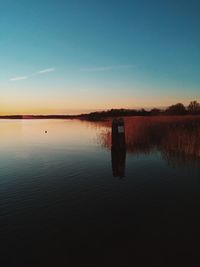 Scenic view of calm lake at sunset