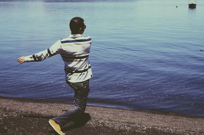 Rear view of boy standing in sea