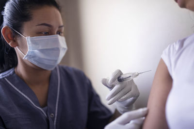 Woman receiving injection in her arm