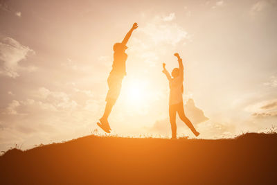 Low angle view of silhouette people against sky during sunset